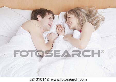 Couple lying in bed together View Large Photo Image Stock Image - Couple lying in bed together. Fotosearch