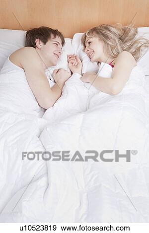 Stock Photo - Couple lying in bed together. Fotosearch