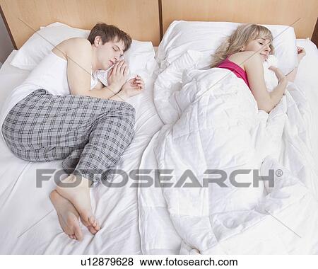 Stock Photo - Couple sleeping in bed. Fotosearch