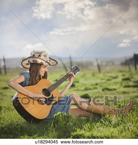 Cowgirl playing guitar in field View Large Photo Image Stock Photography - Cowgirl playing guitar in field. Fotosearch