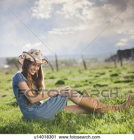 Cowgirl relaxing in field View Large Photo Image Stock Image - Cowgirl relaxing in field. Fotosearch