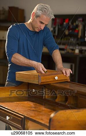 Stock Photography - Craftsman fixing a piece of furniture. Fotosearch