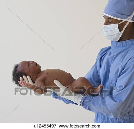 Doctor holding baby View Large Photo Image Stock Photo - Doctor holding baby. Fotosearch