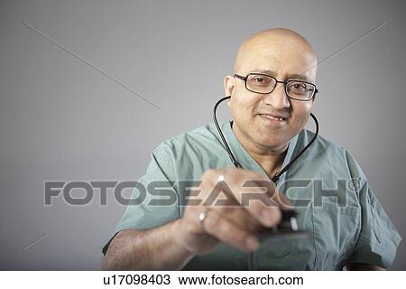 Stock Image - Doctor holding his stethoscope. Fotosearch