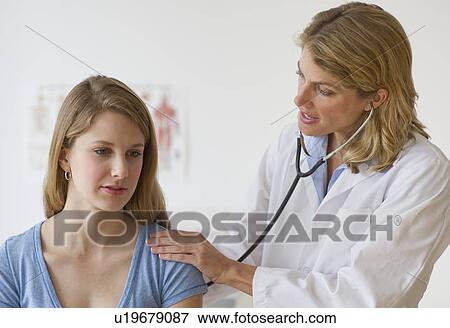 Doctor performing medical exam on patient View Large Photo Image Stock Photo - Doctor performing medical exam on patient. Fotosearch