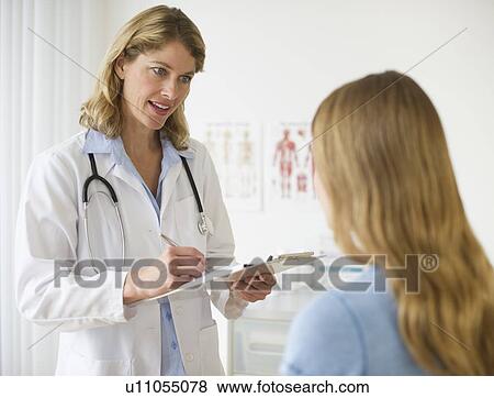 Doctor talking to patient in exam room View Large Photo Image Stock Photo - Doctor talking to patient in exam room. Fotosearch