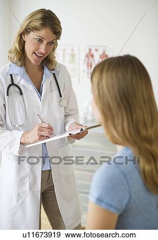 Doctor talking to patient in exam room View Large Photo Image Stock Photo - Doctor talking to patient in exam room. Fotosearch