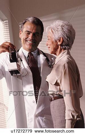 Stock Photo - Doctor weighing senior patient. Fotosearch