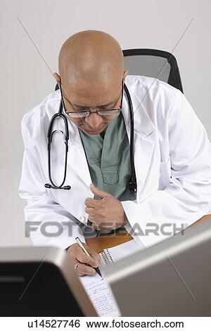 Stock Photograph - Doctor working at his desk. Fotosearch