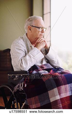 Elderly man sitting in wheelchair while gazing out window View Large Photo Image Stock Image - Elderly man sitting in wheelchair while gazing out window. Fotosearch