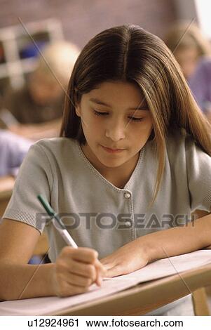 Elementary school student writing at her desk View Large Photo Image Stock Image - Elementary school student writing at her desk. Fotosearch