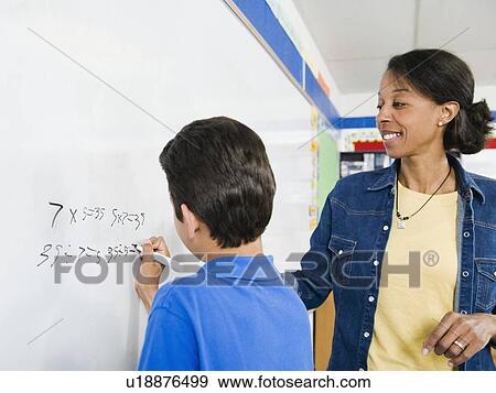 Elementary school student writing math equation on whiteboard View Large Photo Image Stock Photo - Elementary school student writing math equation on whiteboard. Fotosearch