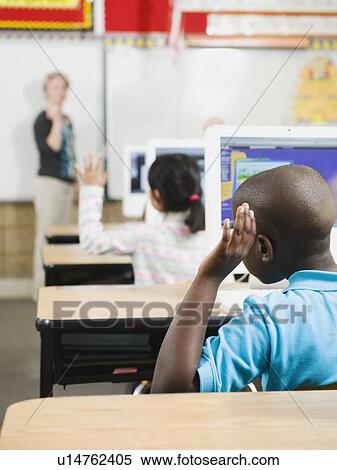 Stock Photography - Elementary school students raising their hands in classroom. Fotosearch
