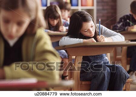 Elementary school students writing at their desk View Large Photo Image Stock Photo - Elementary school students writing at their desk. Fotosearch
