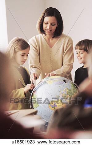 Elementary school teacher showing globe to students View Large Photo Image Stock Image - Elementary school teacher showing globe to students. Fotosearch