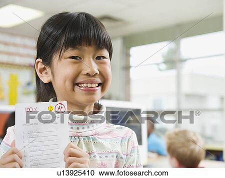 Elementary student holding an A grade paper View Large Photo Image Stock Image - Elementary student holding an A grade paper. Fotosearch