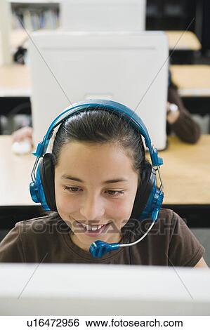 Elementary student wearing headphones in classroom View Large Photo Image Stock Photograph - Elementary student wearing headphones in classroom. Fotosearch