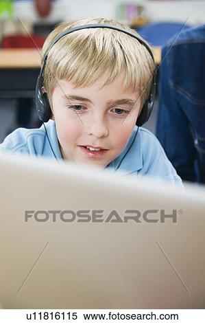 Elementary student wearing headphones in classroom View Large Photo Image Stock Photography - Elementary student wearing headphones in classroom. Fotosearch