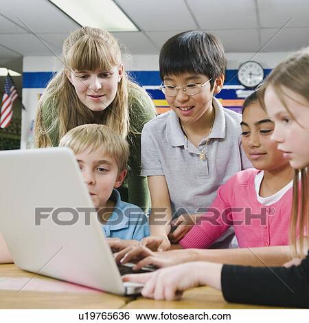 Elementary students looking at laptop View Large Photo Image Stock Photograph - Elementary students looking at laptop. Fotosearch