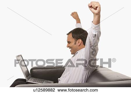 Excited man looking at laptop View Large Photo Image Stock Image - Excited man looking at laptop. Fotosearch