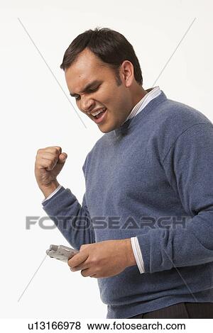 Excited man reading text message View Large Photo Image Stock Photo - Excited man reading text message. Fotosearch