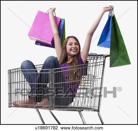 Excited woman sitting in a shopping cart with her purchases View Large Photo Image Stock Image - Excited woman sitting in a shopping cart with her purchases. Fotosearch