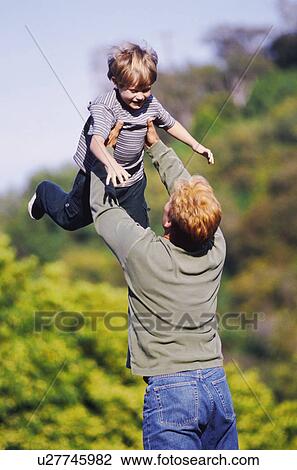 Father playing outside with his young son View Large Photo Image Stock Image - Father playing outside with his young son. Fotosearch