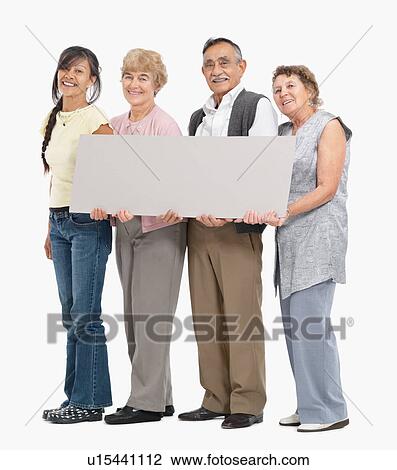 Stock Image - Four people holding a blank poster. Fotosearch