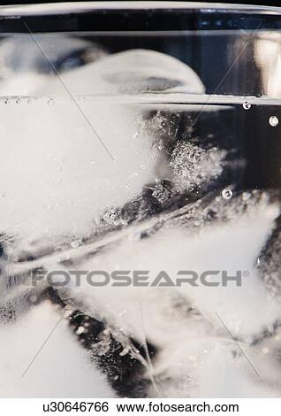 Stock Photograph - Glass of water and ice cubes. Fotosearch