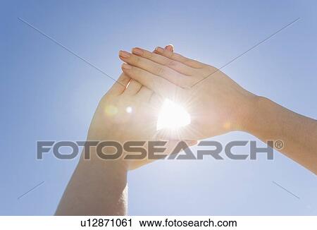 Stock Image - Hands framing sunshine. Fotosearch
