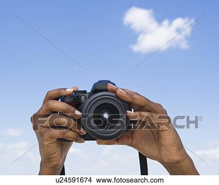 Picture - Hands holding a digital camera. Fotosearch