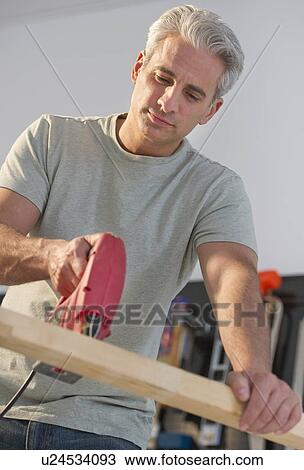 Handyman using an electric drill View Large Photo Image Stock Image - Handyman using an electric drill. Fotosearch