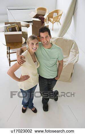 Happy couple standing in their new home View Large Photo Image Stock Image - Happy couple standing in their new home. Fotosearch