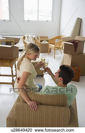 Happy couple toasting with champagne in their new home View Large Photo Image Stock Image - Happy couple toasting with champagne in their new home. Fotosearch