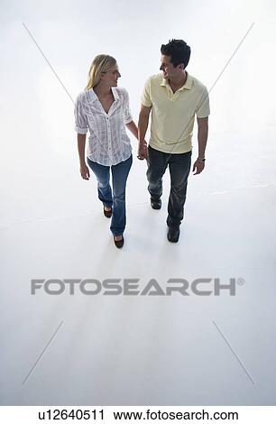 Happy couple walking hand in hand View Large Photo Image Stock Image - Happy couple walking hand in hand. Fotosearch