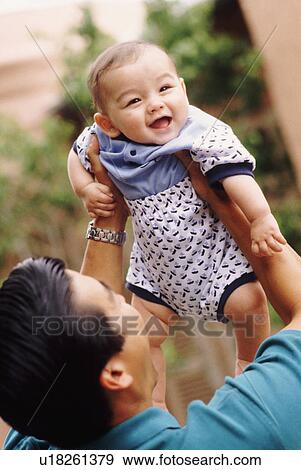 Happy father holding his infant son View Large Photo Image Stock Photo - Happy father holding his infant son. Fotosearch