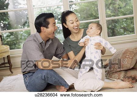 Happy parents sitting with their infant son View Large Photo Image Picture - Happy parents sitting with their infant son. Fotosearch