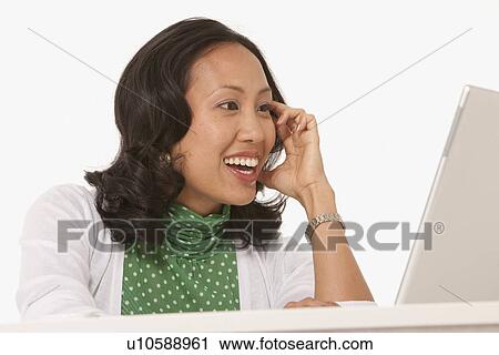 Stock Image - Happy woman looking at laptop. Fotosearch