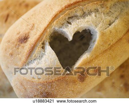 Stock Image - Heart cutout in loaf of bread. Fotosearch