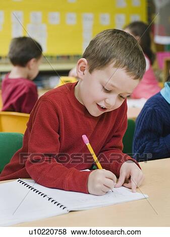 Stock Photo - Kindergarten student writing in notebook. Fotosearch
