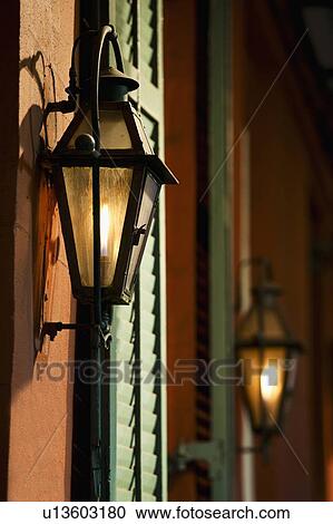 Stock Image - Lanterns on wall of building in French Quarter of New Orleans. Fotosearch