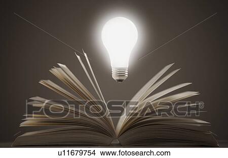 Picture - Light bulb floating above open book. Fotosearch