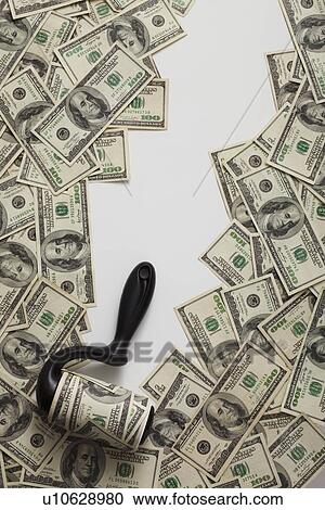 Stock Image - Lint roller picking up money. Fotosearch