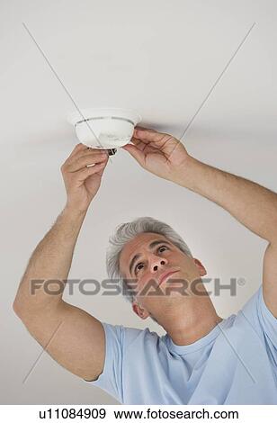 Man changing battery in smoke detector View Large Photo Image Stock Photo - Man changing battery in smoke detector. Fotosearch