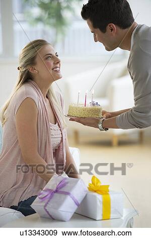 Stock Photo - Man giving birthday cake to woman. Fotosearch
