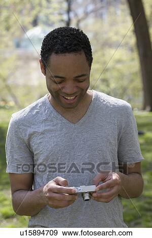 Stock Photo - Man looking at photograph on digital camera. Fotosearch