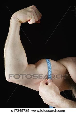 Stock Photography - Man measuring his bicep. Fotosearch