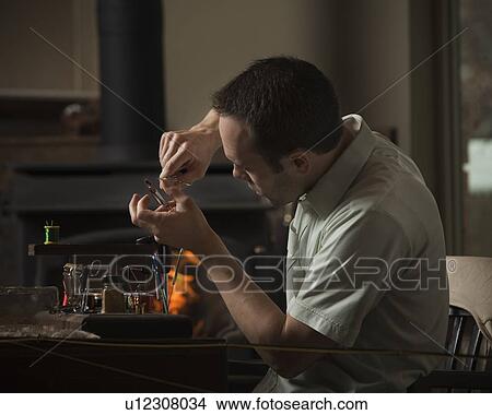 Man repairing fly fishing hook View Large Photo Image Picture - Man repairing fly fishing hook. Fotosearch