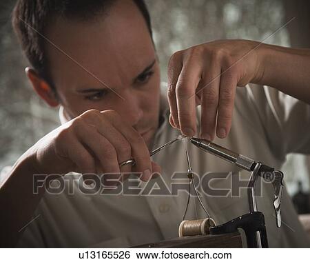 Man repairing fly fishing hook View Large Photo Image Stock Photograph - Man repairing fly fishing hook. Fotosearch