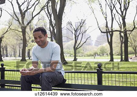 Man sitting on bench in Central Park View Large Photo Image Stock Photo - Man sitting on bench in Central Park. Fotosearch